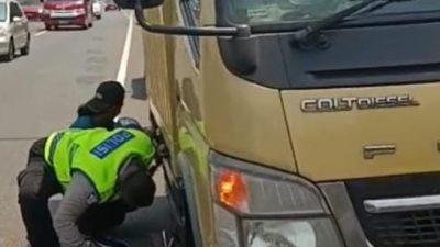 AIPTU Karyono Membantu Menggantikan Ban Mobil Box Yang Melintasi Tol Kilo Meter 22 Serpong MTN 