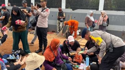 Brimob dan Polwan Polda Metro Bagikan Roti untuk Massa Hari Tani